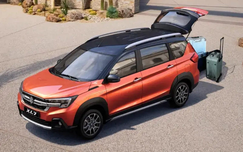 Suzuki XL7 naranja modelo 2024, SUV de 7 asientos con diseño deportivo.